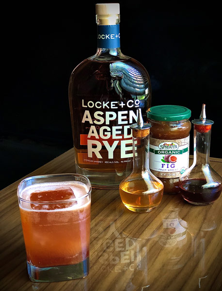 Not A Date Cocktail, bottle of Locke + Co. Aspen Aged Rye Whiskey and ingredients on a wood table