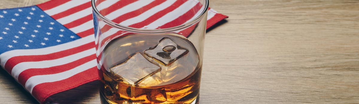 Rye Whiskey on ice with American flag on table hero
