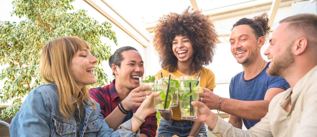 Happy group of multiracial friends drinking and toasting mojito cocktails at brewery bar restaurant - Friendship concept with young people having drunk fun toasting drinks