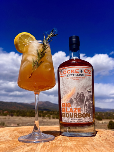 Firebreak Spritz cocktail with lemon and rosemary beside Locke + Co Distilling Big Blaze Bourbon
